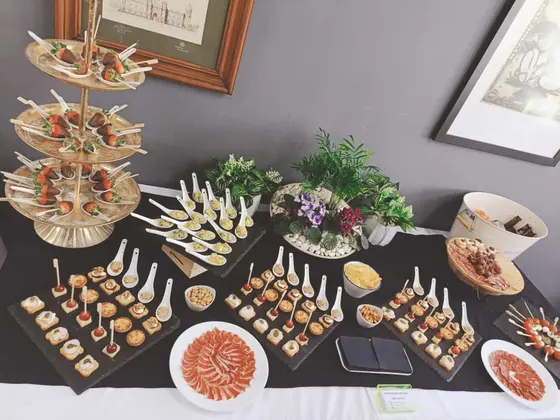 Fresas con chocolate en cucharas sobre torre dorada y canapés, catering para bodas en Valencia