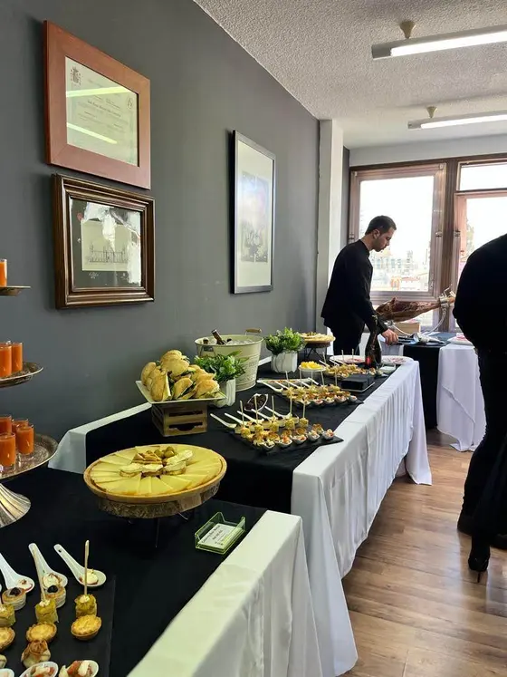 Buffet con tabla de quesos y torre de gazpacho para una celebración