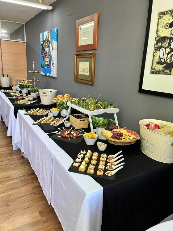 Buffet en mesa larga con canapés y bocadillos para cumpleaños y aniversarios