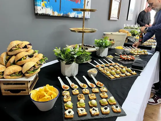Buffet de empresa con mini bocadillos, canapés y flores