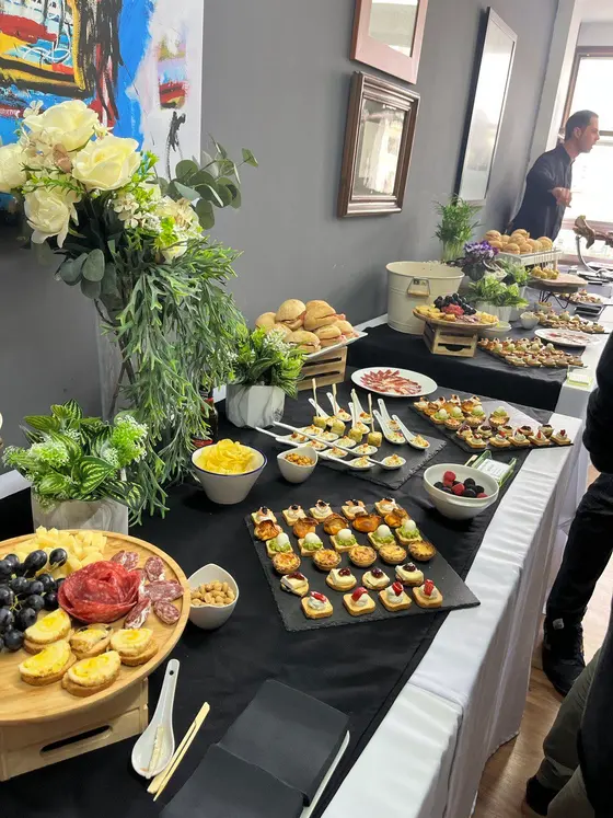 Buffet con flores, canapés y tabla de embutidos para empresa en Valencia