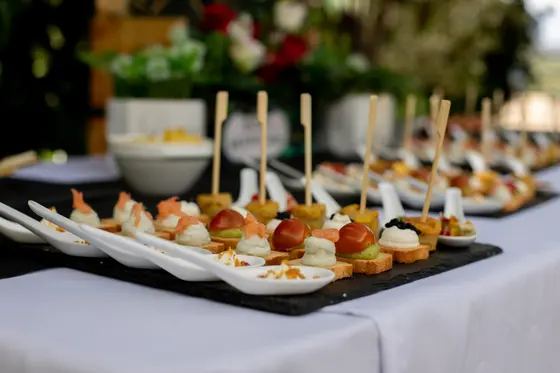 Canapés de salmón ahumado con crema y cucharas de degustación en fila